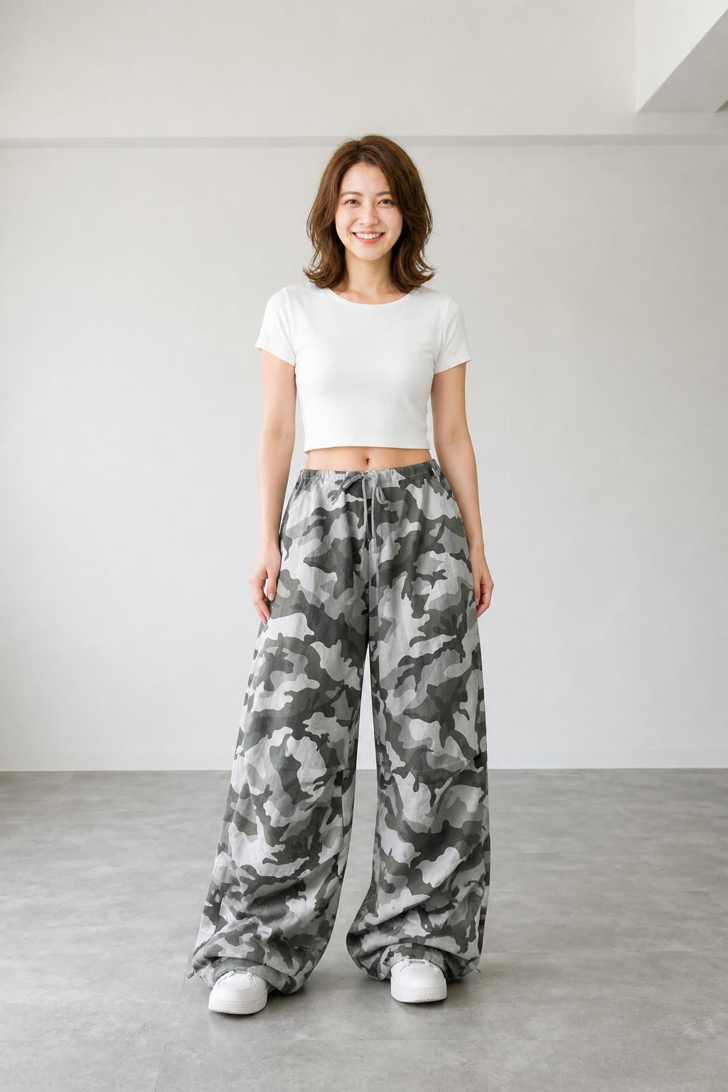 ライトグレーの迷彩ワイドパンツに白の短丈Tシャツと白スニーカーを合わせたレディースの迷彩パンツコーデ